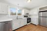 Kitchen featuring tile countertops, stainless steel appliances, pendant lighting, and light wood finished floors