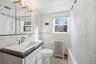 Full bathroom featuring radiator, vanity, plenty of natural light, tile walls, and shower / tub combo