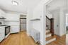 Kitchen with tile countertops, white cabinetry, black gas range oven, radiator, and freestanding refrigerator