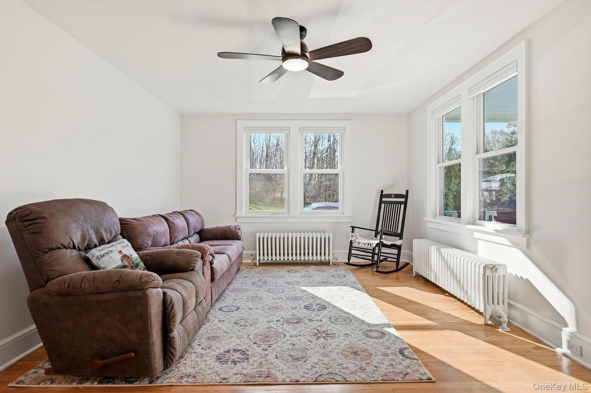 Sitting room featuring radiator, healthy amount of natural light, and light wood-type flooring