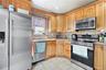 Kitchen with appliances with stainless steel finishes, light stone countertops, decorative backsplash, light tile patterned floors, and recessed light