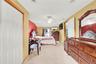 Bedroom featuring light colored carpet, ceiling fan, a baseboard heating unit, a wall mounted AC, and recessed lighting
