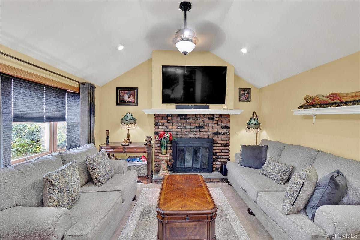 Living area with vaulted ceiling and a brick fireplace