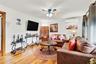 Living room featuring hardwood / wood-style flooring, ornamental molding, an AC wall unit, and ceiling fan