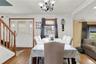 Dining space featuring ornamental molding, wood finished floors, a chandelier, and stairs