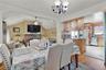 Dining area with a chandelier, light wood finished floors, lofted ceiling, ornamental molding, and recessed lighting
