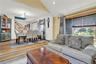 Living area with light wood-style flooring, a chandelier, and stairway