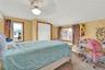 Carpeted bedroom featuring vaulted ceiling, a closet, a ceiling fan, and an AC wall unit