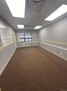 Spare room with a paneled ceiling and dark colored carpet