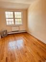 Spare room with light wood-style floors, plenty of natural light, baseboard heating, and lofted ceiling