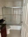 Bathroom with vanity, shower / bath combination with glass door, light tile patterned flooring, and a baseboard radiator