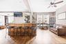 Indoor dry bar with light wood-type flooring, healthy amount of natural light, and a ceiling fan