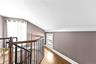 Corridor with lofted ceiling, an upstairs landing, and wood finished floors