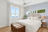 Bedroom featuring wallpapered walls, a water view, an accent wall, a ceiling fan, and light wood-type flooring