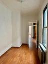 Spare room featuring light wood-type flooring, radiator, and an ornate ceiling