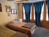 Carpeted bedroom with radiator heating unit and ceiling fan