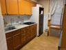 Kitchen featuring light countertops, light wood-style flooring, tile walls, gas stovetop, and radiator