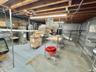 Unfinished below grade area featuring electric water heater and water heater