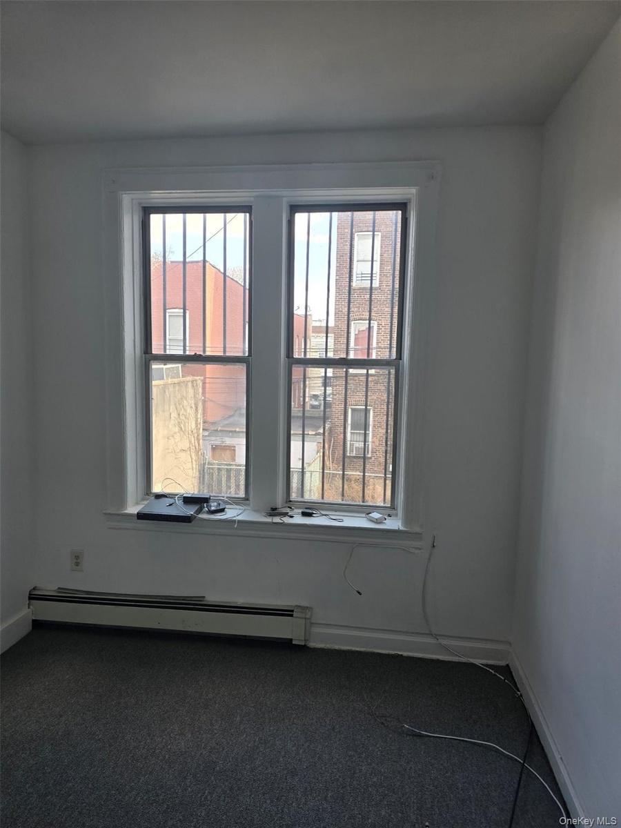 Spare room with a baseboard radiator and carpet