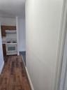 Corridor featuring baseboards and dark wood-style floors