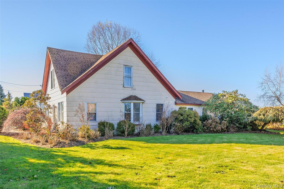 View of property exterior with a yard and a shingled roof
