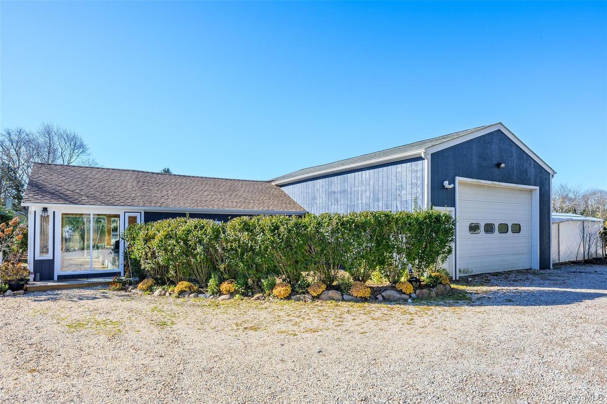 View of front of garage with an outbuilding