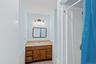 1st floor full bathroom with curtained shower, vanity, and light tile patterned floors