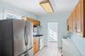 Kitchen featuring freestanding refrigerator, white range with gas stovetop, light countertops, crown molding, and light tile patterned flooring