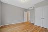 Unfurnished bedroom with light wood-style flooring, a wall unit AC, and a closet