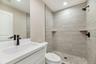 Bathroom featuring vanity, tiled shower, and recessed lighting