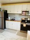 Kitchen with stainless steel appliances, white cabinetry, light marble finish floors, butcher block countertops, and backsplash
