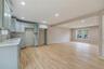 Kitchen featuring recessed lighting, light wood finished floors, light stone counters, beamed ceiling, and open floor plan