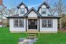 View of front of property featuring a front lawn, roof with shingles, and board and batten siding