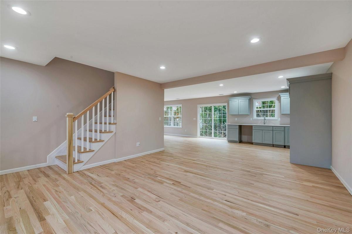 Unfurnished living room featuring recessed lighting, stairs, and light wood finished floors