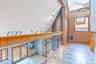 Hallway with healthy amount of natural light, a skylight, wood finished floors, high vaulted ceiling, and heating unit