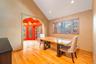 Dining space featuring arched walkways, light wood finished floors, a textured wall, healthy amount of natural light, and vaulted ceiling