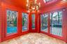Unfurnished sunroom with plenty of natural light, a chandelier, wooden walls, and a skylight