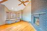 Unfurnished living room featuring light wood-style floors, a brick fireplace, high vaulted ceiling, a ceiling fan, and recessed lighting