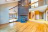 Unfurnished living room featuring wood finished floors, a wood stove, stairs, high vaulted ceiling, and recessed lighting