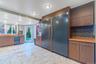 Kitchen featuring tasteful backsplash, built in fridge, brown cabinetry, and modern cabinets