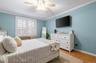 Bedroom featuring ornamental molding, light wood-type flooring, and ceiling fan