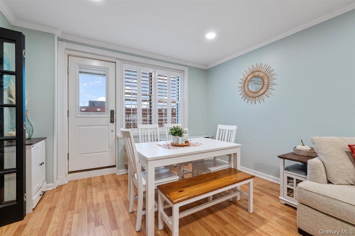 Dining room featuring crown molding, light wood-style flooring, and recessed lighting