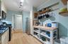 Kitchen featuring appliances with stainless steel finishes, track lighting, ornamental molding, light wood-style flooring, and open shelves
