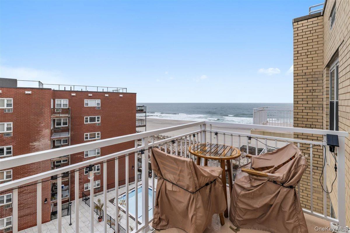 Balcony with grilling area and view of water and beach
