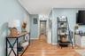 Hallway with electric panel, crown molding, and light wood finished floors