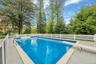 View of swimming pool with a diving board, a fenced backyard, and a patio area