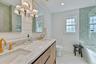 Full bath with healthy amount of natural light, shower / washtub combination, double vanity, light tile patterned flooring, and recessed lighting