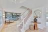 Stairs featuring plenty of natural light, ornamental molding, wood finished floors, and built in shelves