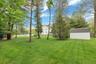 View of green lawn featuring a storage shed