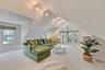 Carpeted living room with lofted ceiling and rail lighting
